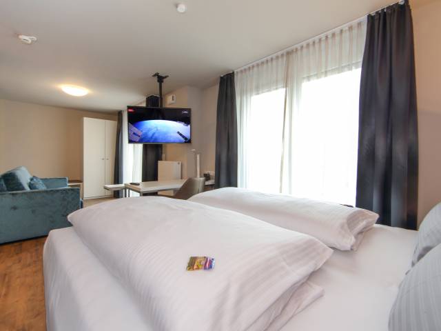 Doppelzimmer mit Bett und Schreibtisch im Estilo Design & Lifestyle Hotel Aalen