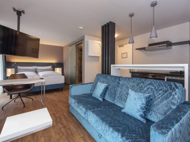 Doppelzimmer mit Küchenzeile und Sofa im Estilo Design & Lifestyle Hotel Aalen