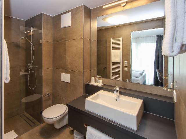 Badezimmer mit Waschtisch und Duschei m Estilo Design & Lifestyle Hotel Aalen